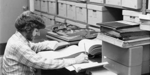 Man processing archival documents at a desk